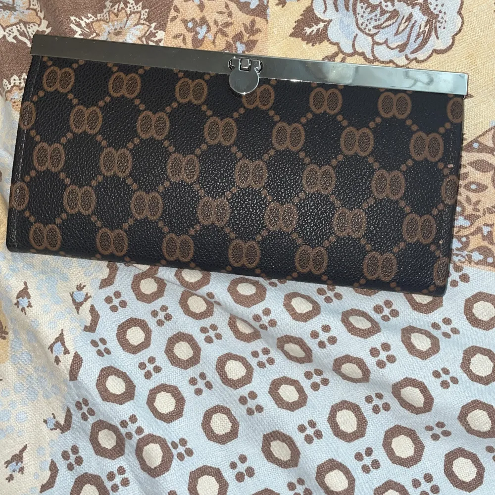 Mörk brun plånbok med ljus bruna detaljer. Väskor.
