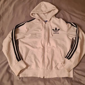 Vit zip-hoodie (adidas) - Vit zip-hoodie (adidas). Passar på mig som har storleken XXS/XS💗 Finns att hämta i alsike/knivsta😊 köparen betalar för frakten om den behöver postas💗