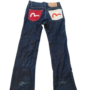 evisu jeans  - As nice baggy jeans från Evisu. Tyvärr lite slitna nertill men man tänker inte riktigt på det. Innerbenslängd: 80 cm. Ytterbenslängd: 109 cm. Midjemått mätt rakt över: 42 cm