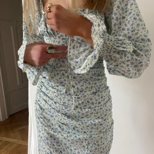 Adoore sommarklänning  - Sommarklänning med långa armar från adoore. Nypris 1350kr jag säljer för 450kr. Beställde hem i veckan men kunde inte knäppa ihop den då jag är 34/36. 