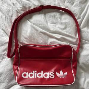 Adidas retro axelremsväska i röd. väskan har några fläckar men i övrigt bra skick!❤️köpte den på plick och jag har endast använt den en gång!