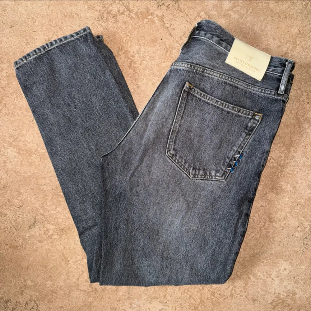 Grå jeans av märket Scotch & Soda med väldigt fina detaljer som gör jeansen mer unika Storlek: 32x32. Jeans & Byxor.