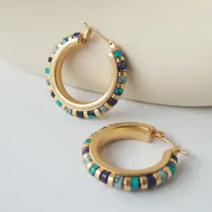Enhance your bohemian style with these stunning gold hoop earrings, featuring beautiful turquoise and lapis lazuli accents. The unique combination of vib