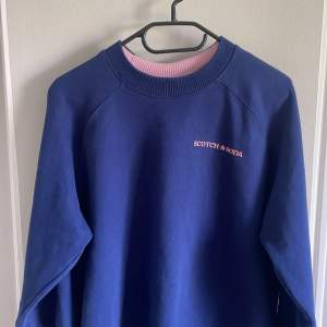 Snygg Scott & Soda sweatshirt i marinblå färg med rosa detaljer. Bra skick och sparsamt använd. Nypris 1100 kr. Storlek (M) passar (S)