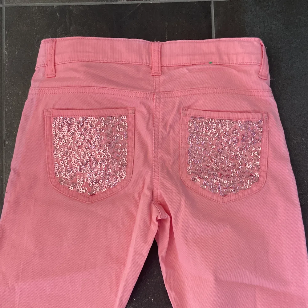 Rosa skinny Lågmidjade jeans i strl 150: xxs-xs. Aldrig använda men utan prislapp. De är från United colors och bennetton. De är strechiga och fina med glittriga bak fickor.. Jeans & Byxor.