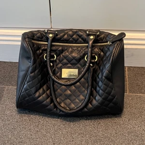 Svart handväska  - Svart handväska från AMISU i väldigt fint skick. 30 cm bred och ca 17 cm hög. Kom privat för fler bilder. Använd gärna köp nu!