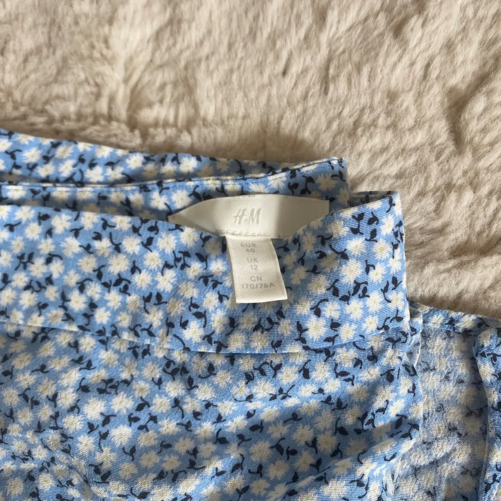 Fin blå blommig kjol från H&M i storlek 40 med slitts (och dragkedja på sidan, se sista bild). Säljer då den inte kommer till användning och är bara använd cirka 5 gånger🩵. Kjolar.