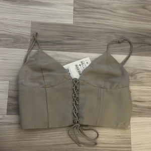 Söt zara topp (knytdetalj) - Jättesöt topp med knytdetalj från zara som tyvärr aldrig kunnat användas då mamma köpte den till mig o den var för liten