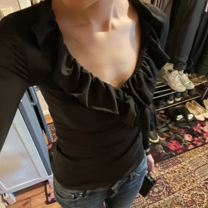 Tajt topp från New Yorker - Tajt och stretchig topp med volanger från New Yorker. Sparsamt använd.