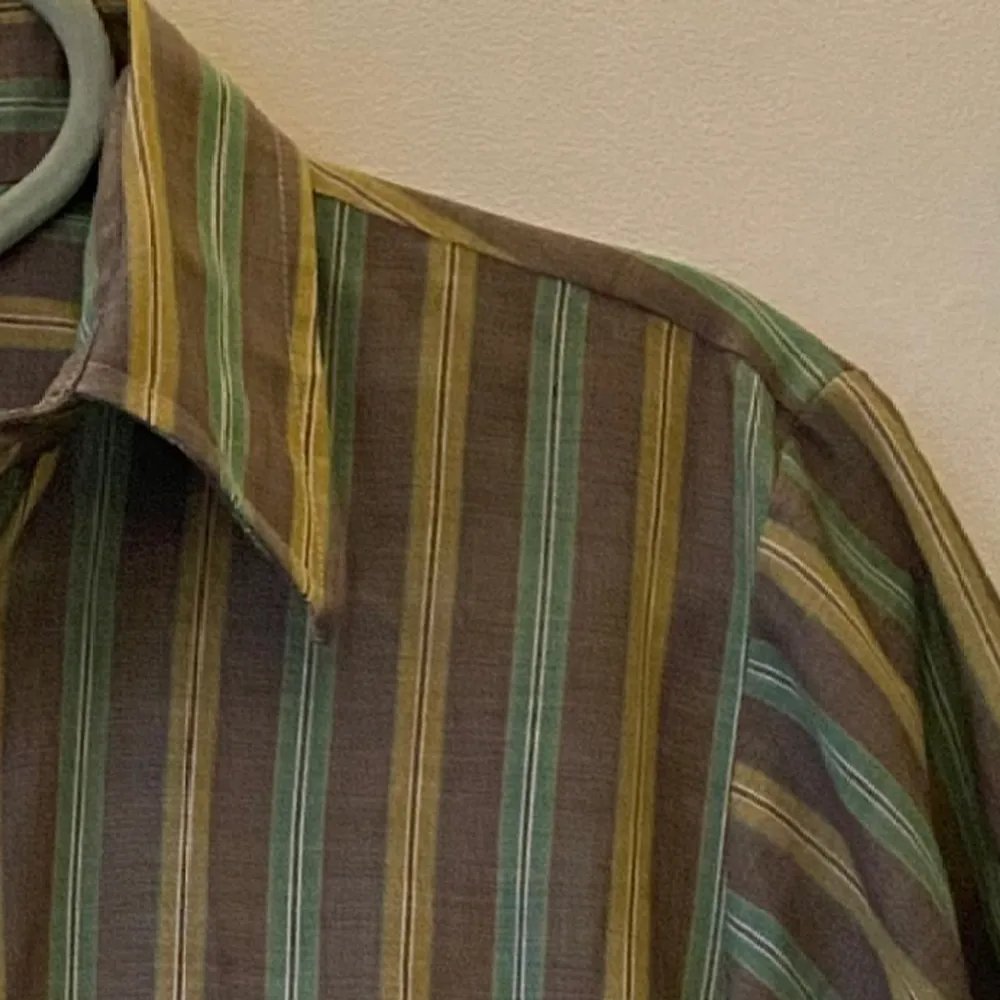 Säljer denna superfina randiga retro-skjortan i färgerna grön, gul och brun✨den är kortärmad och av tunt material. Märke: okänt, men köpt på second hand. Oerhört fint skick! Skriv om du har frågor :). Skjortor.
