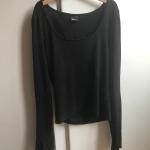 Svart långärmad tröja med urringning och slit vid handleden💕 - Det är en jätte fin svart tröja med urringning och slit. Den sitter tajt på och är i storleken xs. Den är ifrån gina tricot💗