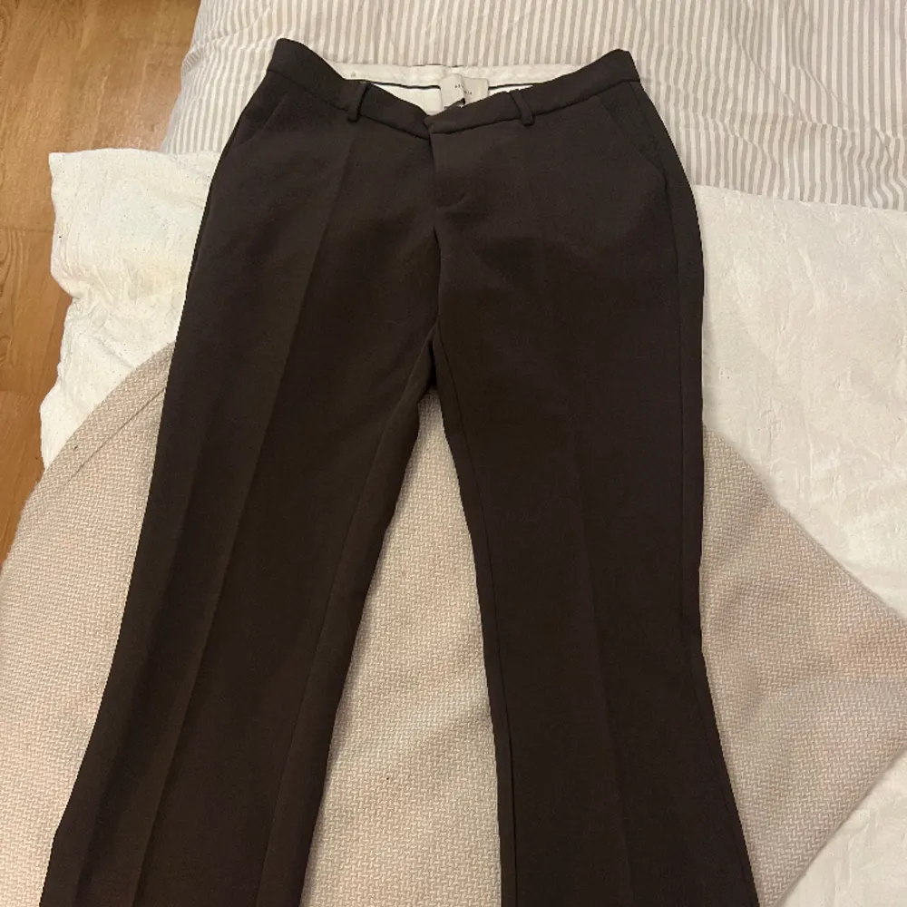 Mörkbruna kostymbyxor från Neo Noir i storlek 36, använda 1 gång. De är låga i midjan, kan skicka första bilden i chatten så ni får se resten av byxan . Jeans & Byxor.