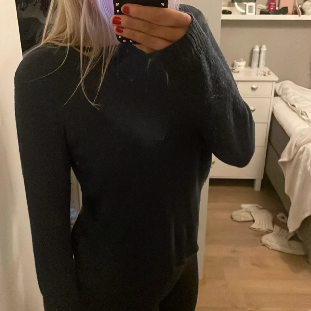 Marin blå stickad tröja, lagom tjock för att ha över något lätt under sommaren typ. Köparen står för frakt.. Neuleet.