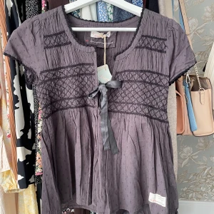 Odd Molly blus/tröja - Helt oanvänd kortärmad blus från Odd Molly (prislapp kvar). I en mörkgrå färg, den ser nästan lika ut på bilden men inte i verkligheten! Strl 0, passar XS/S