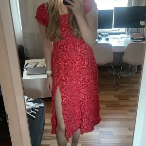 Långklänning - Lång vitblommig röd klänning går att ha Offshoulder eller över axlarna. Med slits på vänsterben 