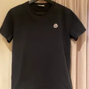 Säljer en svart Moncler T-shirt i storlek 14 år (164) Säljes i befintligt skick. Köpt på Nk i Göteborg. Nypris 1249kr Mitt pris 299kr