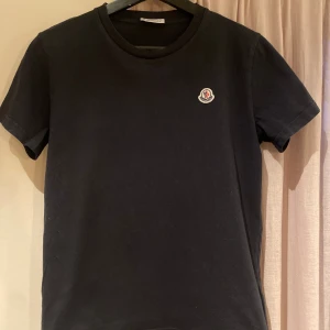 Moncler T-shirt - Säljer en svart Moncler T-shirt i storlek 14 år (164) Säljes i befintligt skick. Köpt på Nk i Göteborg. Nypris 1249kr Mitt pris 399kr