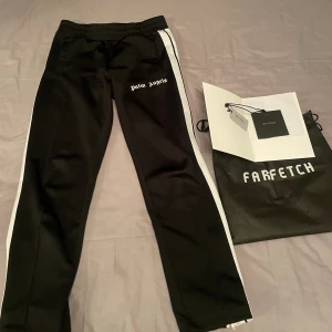 Palm Angels Byxor - Tjabba. Säljer nu dessa stilrena Palm Angels byxor | Köpta från Farfetch, Kvitto med mer fås med | Riktigt bra skick förutom ett ”hemmafix” på höger ficka (se bild 3), absolut inget som man lägger märke till 🤙| Hör av dig vid frågor eller funderingar