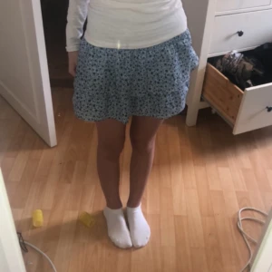 Blå kjol - Blå kjol med blommor säljer för den är för liten och ej används💗