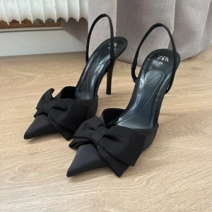 Zara klackar rosett - Svarta klackar med rosetter, från Zara. I nyskick, endast använda en gång! Storlek 39. Nypris 379 kr. Klackhöjd 10cm. Skriv om du har några frågor:)