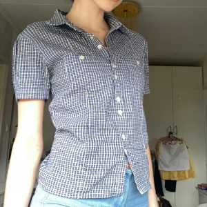 T-shirt skjorta - Jätte snygg blå/vit rutig t-shirt skjorta. Knappar hela vägen ner🌸 Jätteskönt och stretchigt material! Perfekt till nu när det börjar bli varmaste ute🌸 Nyttskick!