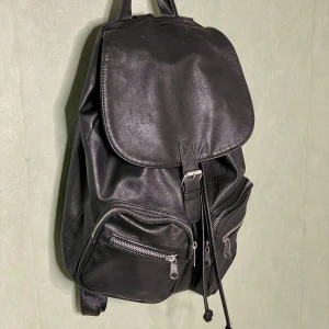 Svart fejkskinn ryggsäck✨ - En snygg svart ryggsäck som passar till allt!✨Väl använd🌱 Lite små märken på framsidan, men inget som man tänker på💚