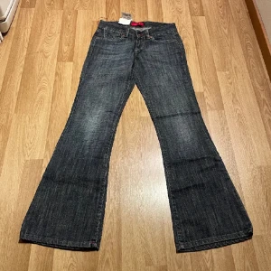 Lågmidjade bootcut jeans - Super fina jeans köpta här på plick, bilderna är från den tidigare ägaren. Prislappen är kvar! Innerbenslängd 77cm, midjemått rakt över 34