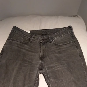 Grå jeans - Tja säljer ett par byxor modellen är regular och storlek 30/32 En liten defekt den ser ni på bild 3 men ser inte den från nära håll  Från hm 