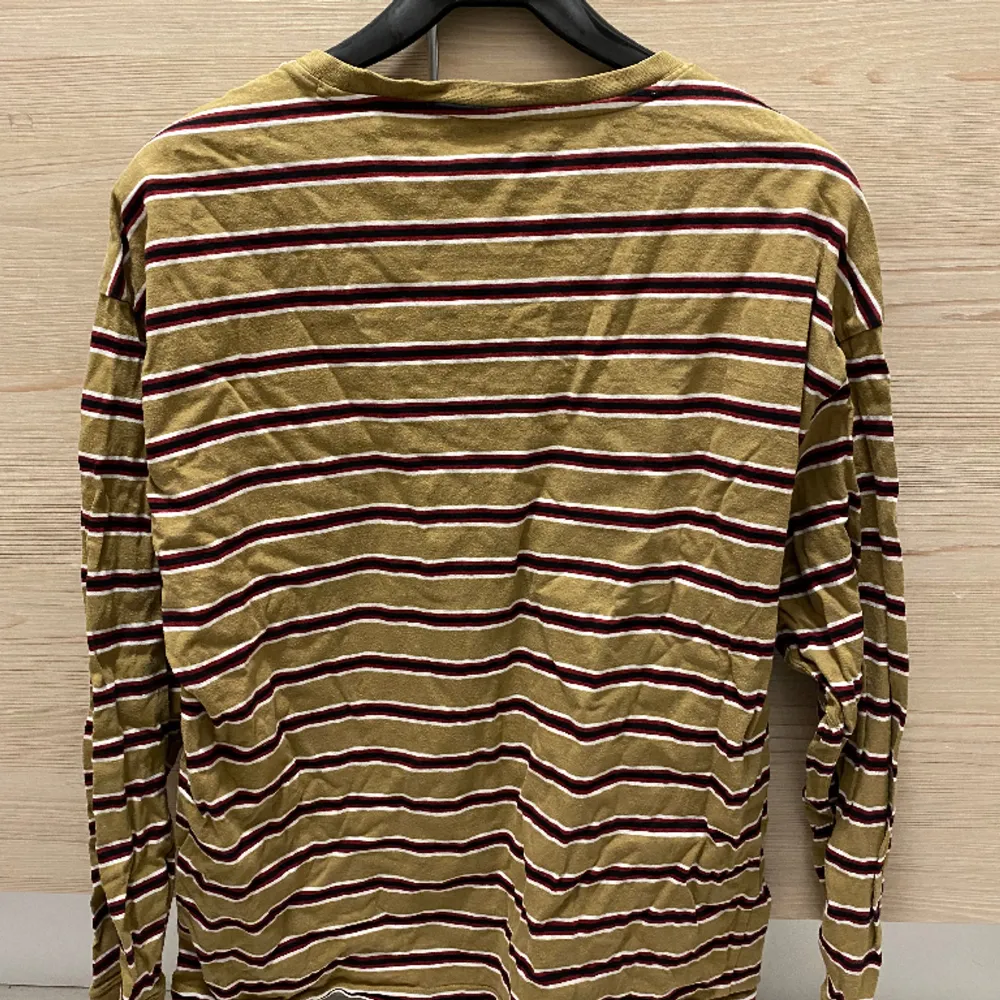 Långärmad tröja från New Look. Brun/beige, röd, svart och vit-randig.. T-shirts.