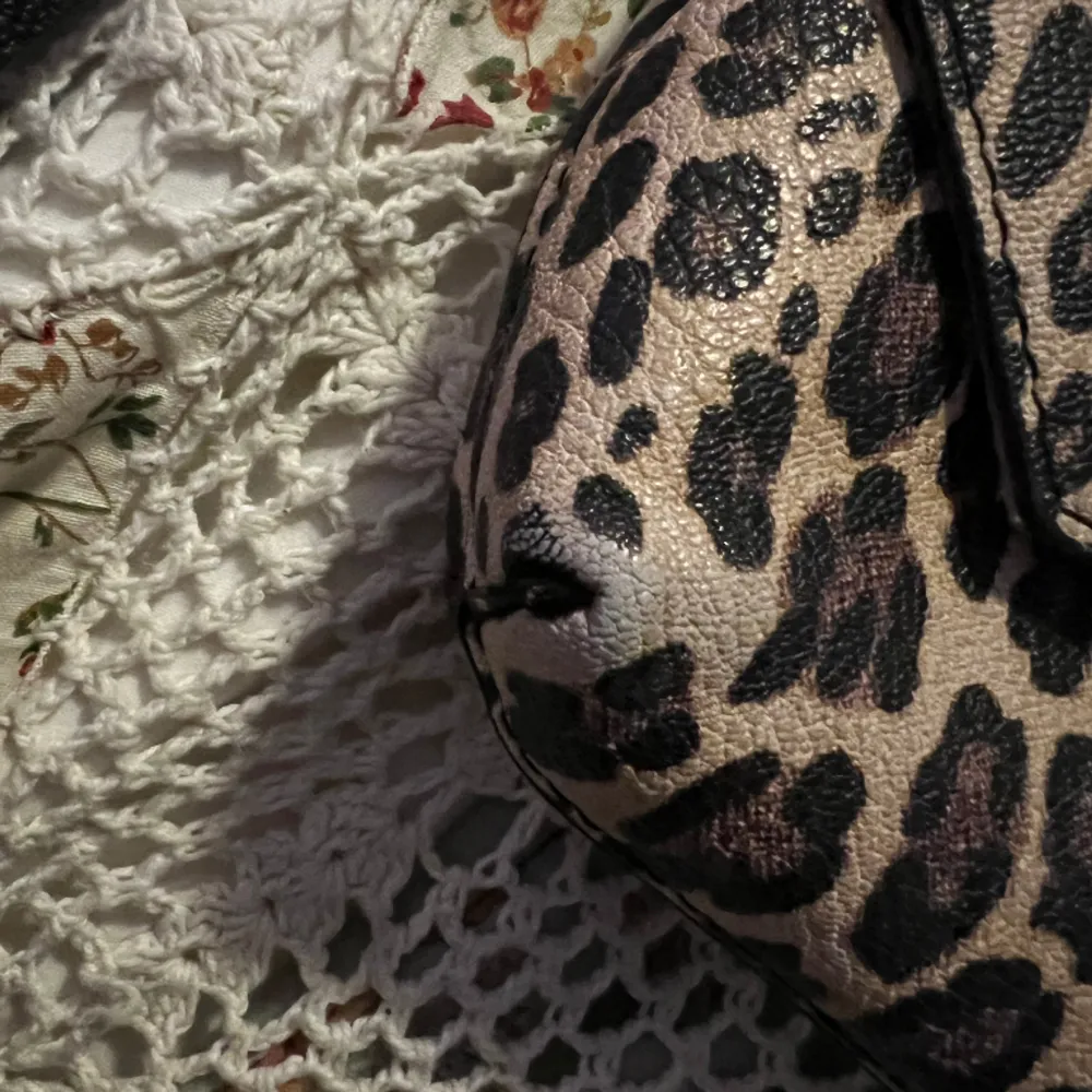 Leopardmönstrad väska från DON DONNA. Färgen har gått bort lite vid nedre hörnen men annars i mycket fint skick. Jätte fin och ren på insidan också. Måtten är 20x15 cm. Ett justerbart band och ett mindre svart band tillkommer. . Accessoarer.