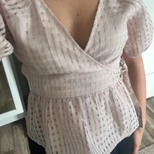 Blus med volang  - En söt topp/blus med volang som man knyter i sidan, helt oanvänd 