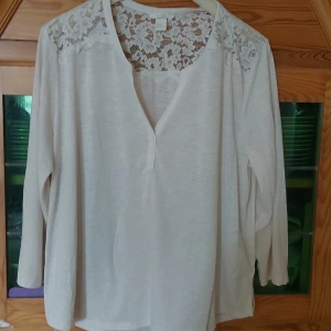 Vit blus med spetsdetaljer  - Fin vit tunn tröja med spetsdetaljer vid axlarna och övre ryggen. Fint skick Liten XL, mer som en L