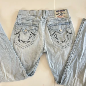 True Religion jeans - Svinsnygga ljusblå True Religion jeans med detaljerade sömmar och fickor. Lågmidjade och långa i benen! Skriv vid fler frågor❣️priset plus frakt gäller😊skriv gärna innan du använder ”köp nu”!
