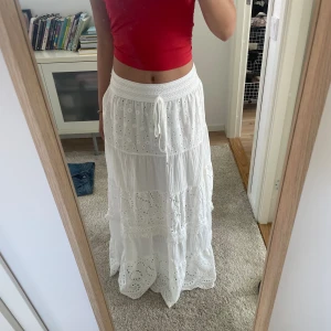 Vit långkjol  - Långkjol med fina detaljer. Använt 2-3 ggr så den är i väldigt bra skick. Ny priset var 700. (L97 W68) Materialet vid midjan är stretchigt så den passar nog de flesta. Skriv gärna för fler frågor💗