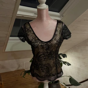 Spets topp - Topp i spets med beigt siden tyg under🖤går att ha på båda hållen! Dragkedja på sidan🖤 tror den är handgjord! 