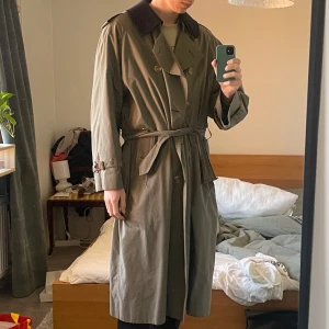 BURBERRY Vintage Trenchcoat olivfärgad - Mycket snygg burberry rock med löstagbar fodring. I gott skick, det enda som har slitage är spännet runt midjan, det funkar men hat knytits många gånger (som jag gör på bilden) så det är lite skruvat.  För referens är jag 188 lång