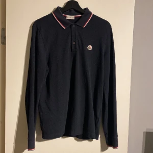 Moncler långärmad piké - Stilren långärmad piké från Monclet. Lite urtvättad i färgen men inget folk anmärker på. Nypris på denna är 3499:-