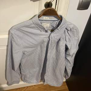 Randig blå-vit skjorta från Lager 157 i storlek L.  Finns att hämta i södra Stockholm, köparen står för eventuell frakt.