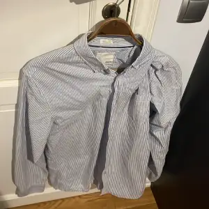 Randig blå-vit skjorta från Lager 157 i storlek L.  Finns att hämta i södra Stockholm, köparen står för eventuell frakt.