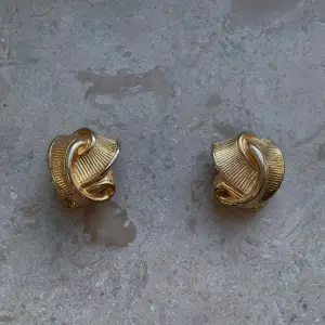 Set of Vintage Golden Clip earrings with a ribbon like texture. A lovely vintage gift.   Some light fading in the gold color, not noticeable when worn. Very Good Condition  Clip Earrings. 3CM Wide