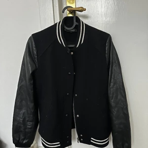 Cool bomberjacka med stripes - En supercool bomberjacka som har läderärmar och sen typ en ull variant resterande tyg :) oxå använt mycket förut men inte längre tyvärr! Står S men passar M oxå skulle jag säga :)