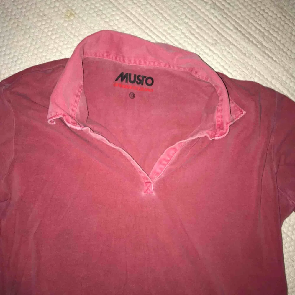 Hallonröd/rosa pikétröja i stretchigt tyg från Musto. Retro design. Frakt tillkommer. Tröjor & Koftor.