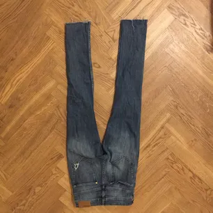 Ett par blåa högmidjade jeans med hål i från H&M i strl S.. Jeans & Byxor.