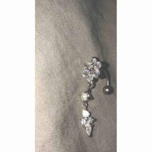  - Navelpiercing ✨Denna är endast öppnad ur förpackning, absolut inte använd. Kirurgisktstål. Nypris 359 Diamant blomma med små hängande  diamanter/ stenar.  Jag fraktar ( köparen står för frakt kostnaden) Om ni undrar något är det bara att fråga!