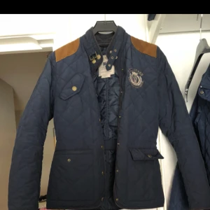  - Blå lexington vårjacka med bruna mocka axlar. Har knappar istället för dragkedja Den är använd ett fåtal gånger våren 2016 har sedan dess bara hängt.  Nypris:1400kr 