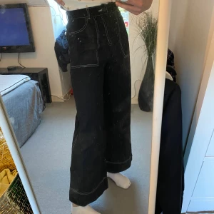 Svarta jeans - Ett par svarta jeans från monki med vita sömmar. Storlek 36 som sitter snyggt och bra på, jag är 171 cm lång. 