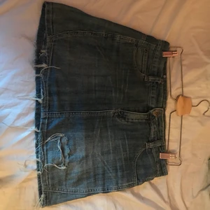 Vintage jeanskjol med slitningar - Kjolen är använd fast i bra skick! Köpt på second hand för 100 kr och har några slitningar som fanns där sen tidigare. Slitningarna ser dock ut att vara menade att vara där! Ganska kort i passformen! Köper står för frakt❤️