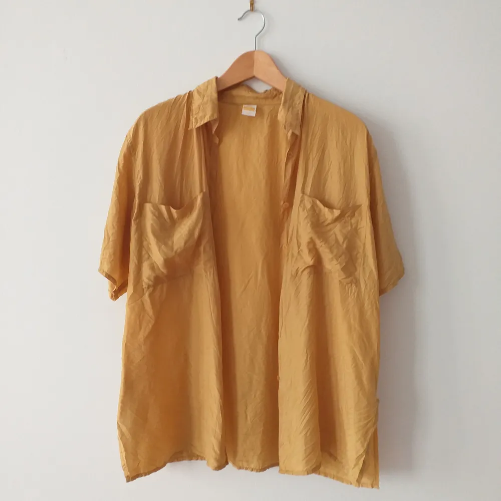 Pris är diskuterbart. Vintage silkesskjorta i guld-gul färg. Jättefin i storlek 40, oversize så passar alla. Jätteskön och inköpt på pop Stockholm. Lagad precis vid kragen på baksidan, syns knäpp men kan skicka bild på! Frakt 39kr.. Skjortor.