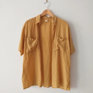 Vintage silkesskjorta i guld-gild färg - Pris är diskuterbart. Vintage silkesskjorta i guld-gul färg. Jättefin i storlek 40, oversize så passar alla. Jätteskön och inköpt på pop Stockholm. Lagad precis vid kragen på baksidan, syns knäpp men kan skicka bild på! Frakt 39kr.