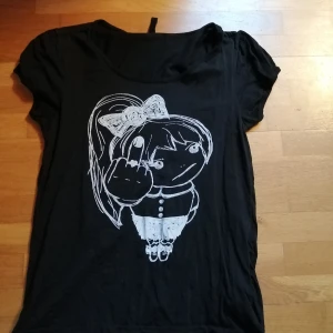 Top - Svart top med print. Använd men fortfarande i fint skick. Storlek L men funkar på M också. Har ej möjlighet att visa hur det ser ut på. Priset är inkl vanlig frakt. 